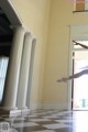 A person jumping in the air in a room with columns.