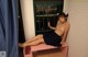 A naked woman sitting on a pink bench in front of a window.