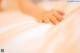 A close up of a person's hand on a bed.