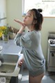 A woman standing in a kitchen next to a sink.