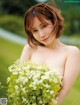 A woman holding a bunch of flowers in her hands.