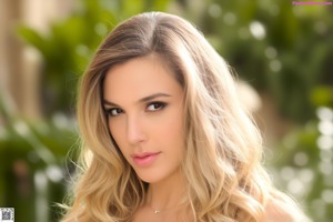 A beautiful young woman with long blonde hair posing for a picture.